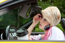 Woman driving and applying makeup